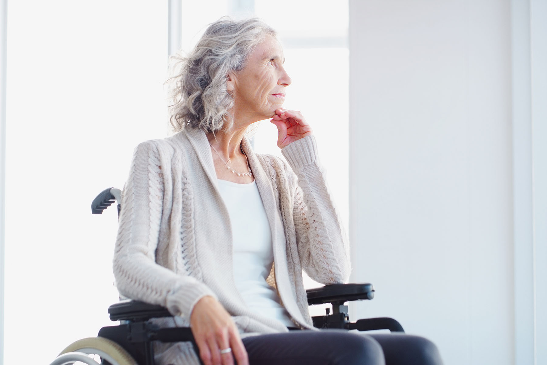 Older lady sitting in wheelchair looking out the window