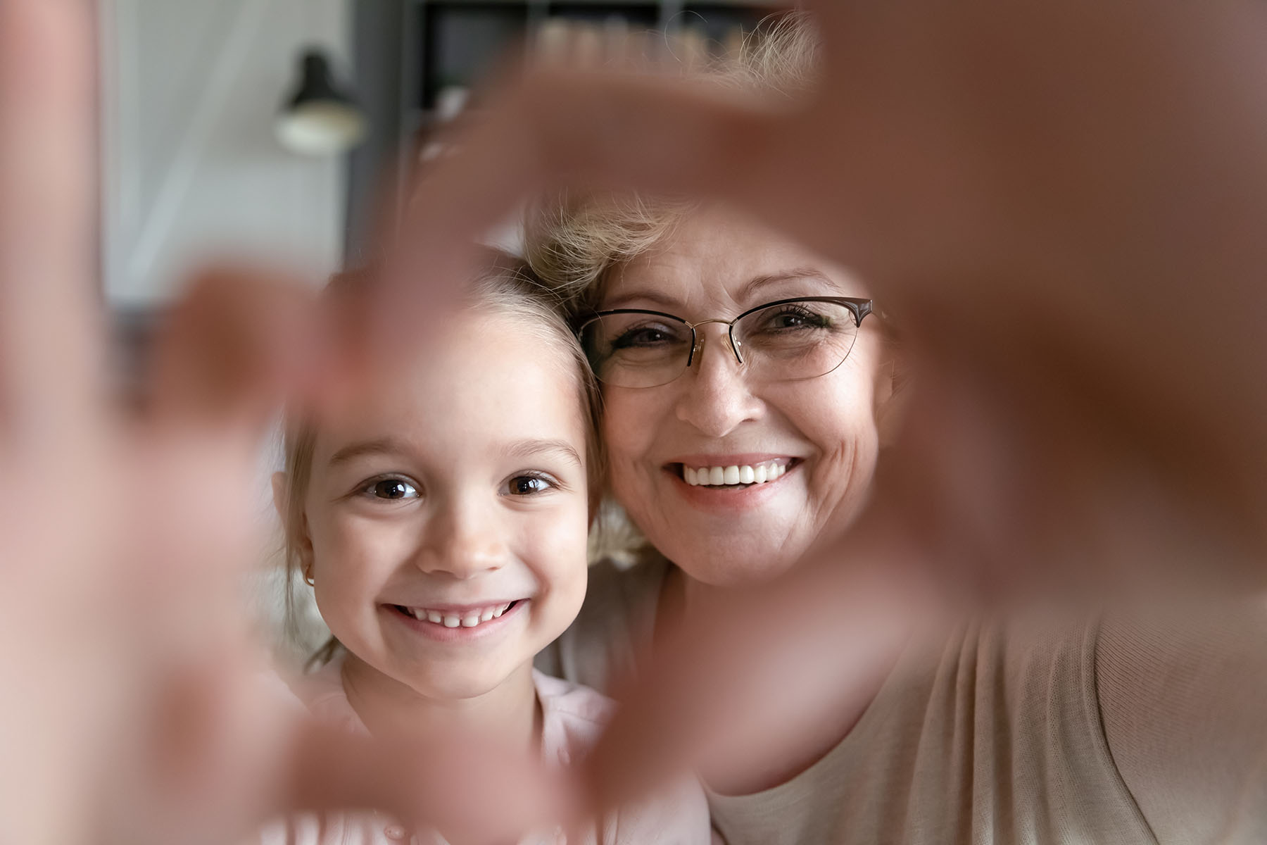 Lady and girl forming a heart with their hands