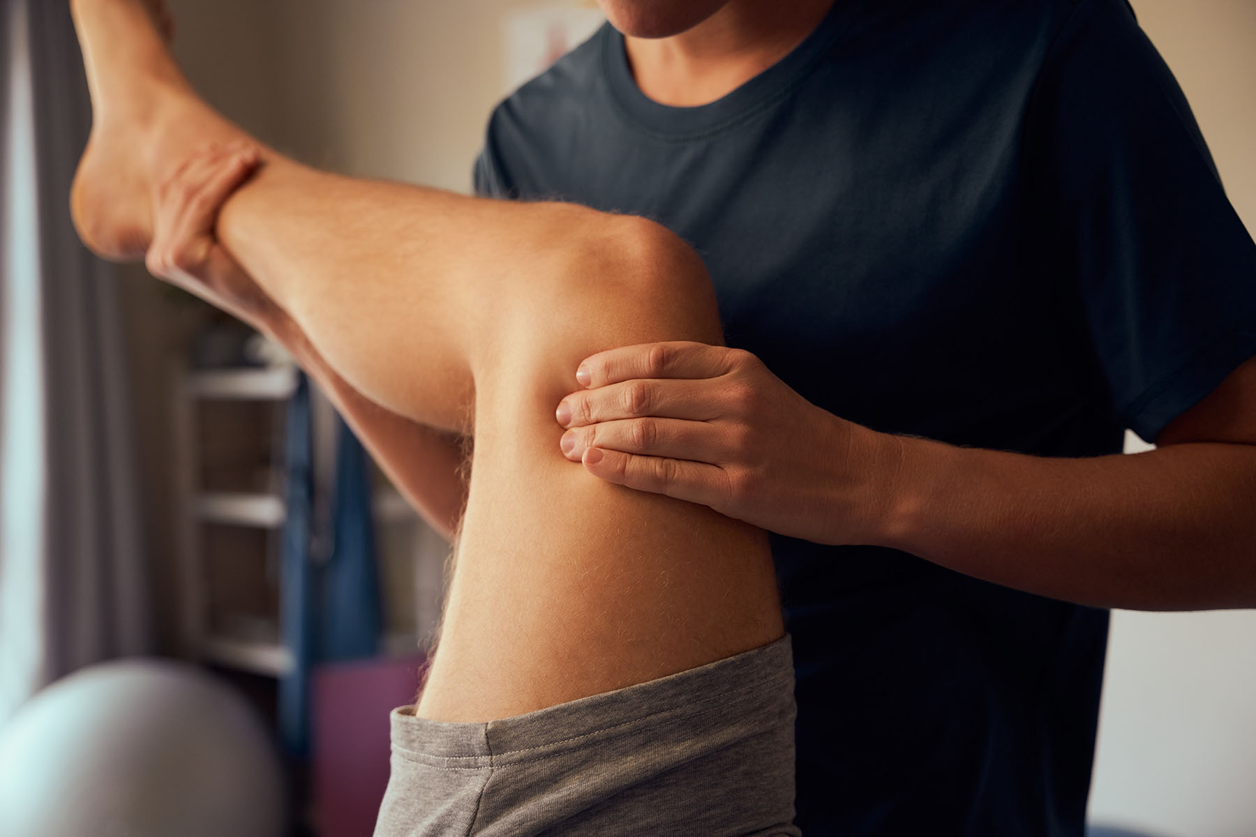 A practitioner holding a persons leg and pressing their knee